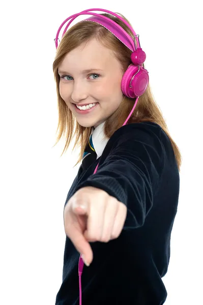 Pretty musical girl enjoying music and pointing at you — Stock Photo, Image