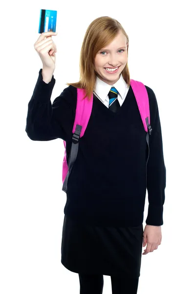 Teen girl in uniform holding up a cash card — Stock Photo, Image