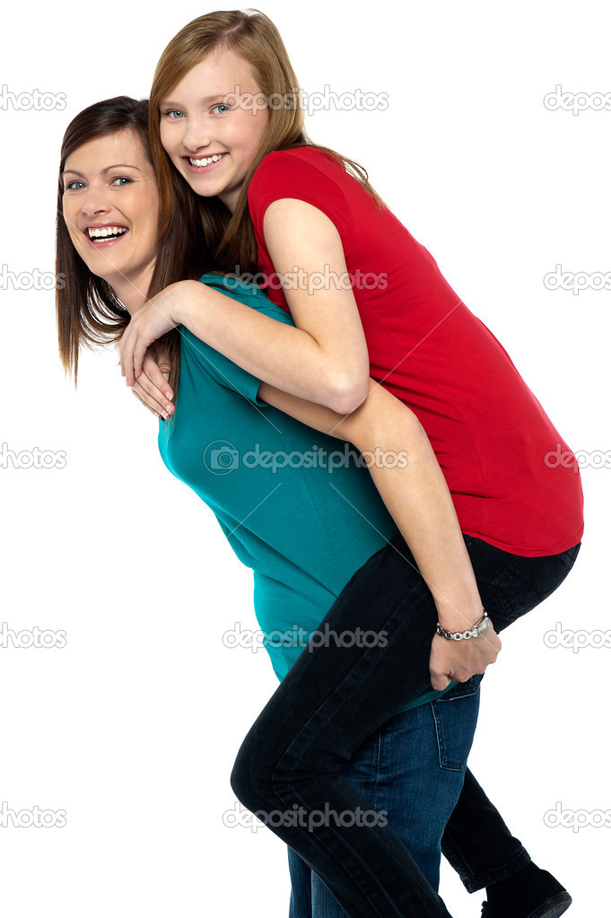 Teenage girl giving friend piggyback ride Stock Photo - Alamy