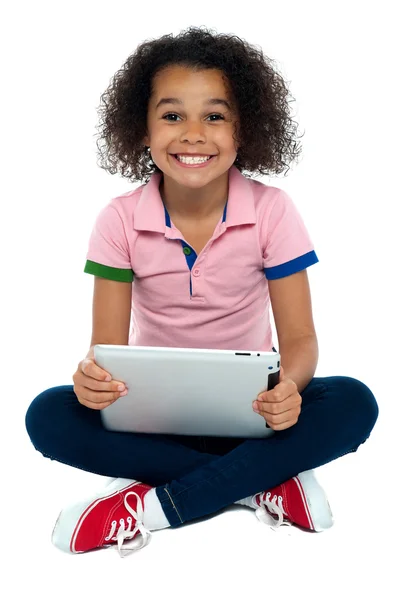 Cool fille enfant assis sur le sol tenant tablette pc — Photo