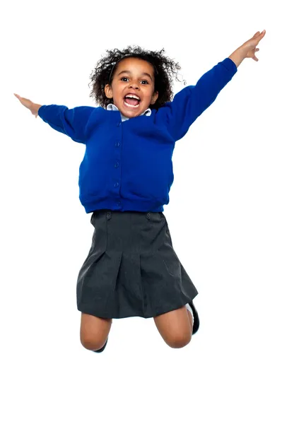 Miúdo da escola jubilante a saltar alto no ar — Fotografia de Stock