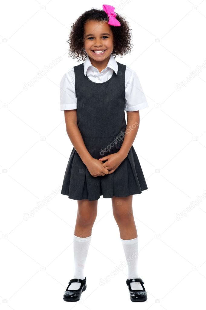 Cheerful young kid in pinafore dress posing smilingly