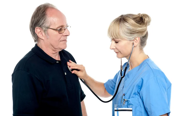 Doctora examinando a un anciano — Foto de Stock