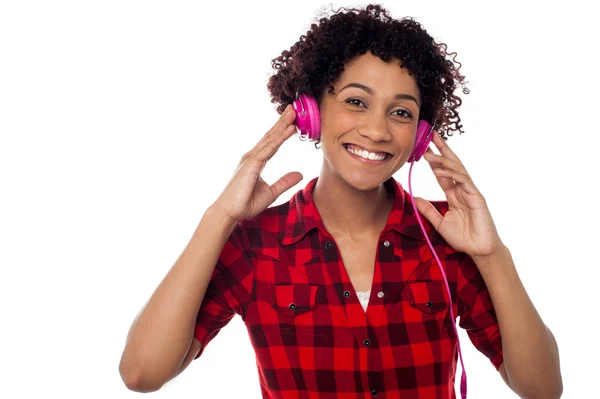 ピンクのヘッドフォンでの女性の笑みを浮かべてください。 — ストック写真