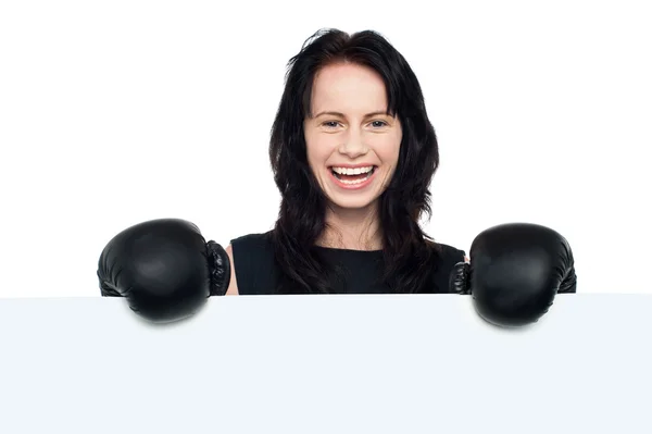 Woman with boxing gloves on posing behind billboard — Stock Photo, Image