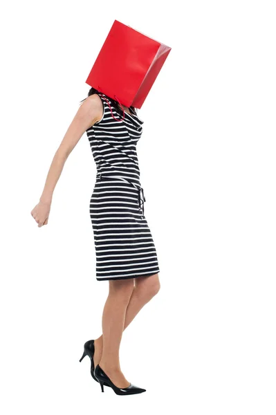 Kvinna som täcker hennes ansikte med shopping väska — Stockfoto