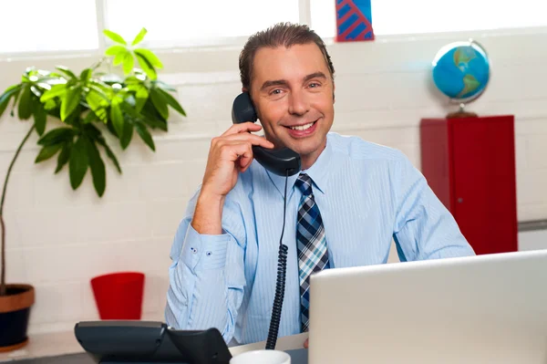 Smiling manager in middle of business interactions — Stock Photo, Image