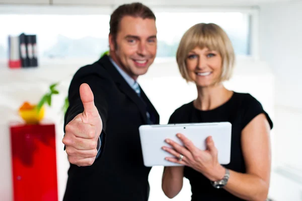 Secretária com um tablet posando com seu chefe de sucesso — Fotografia de Stock