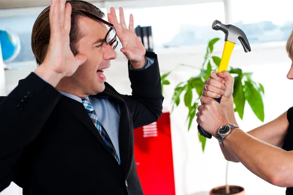 Kvinnan hotar hennes chef, hålla hammare. — Stockfoto