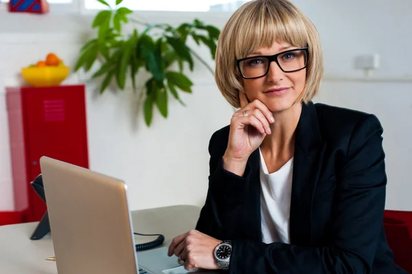 Thoughtful business lady seated in office — Stock Photo, Image