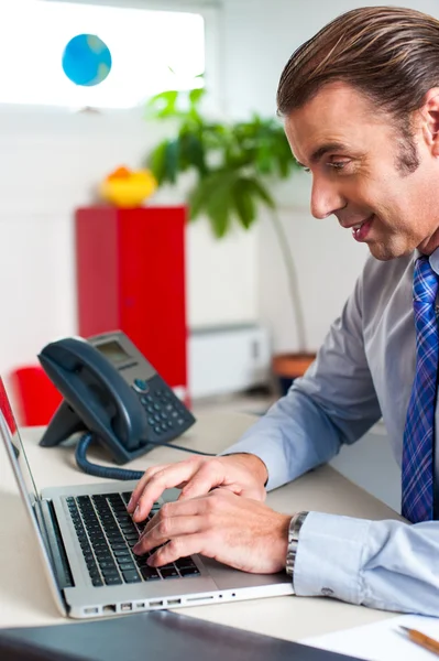 Hombre de negocios escribiendo informe en un ordenador portátil — Foto de Stock