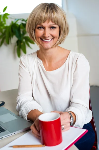 Femme décontractée au bureau profitant de sa pause café — Photo