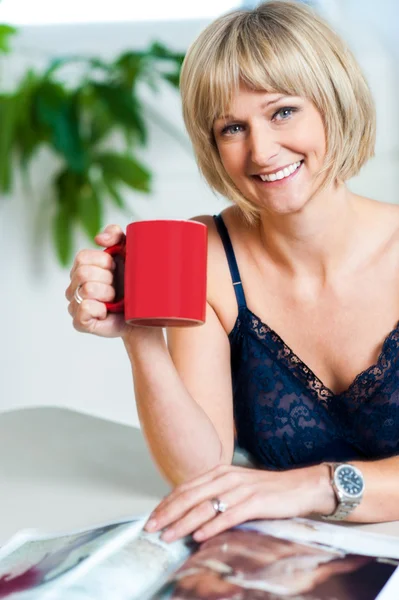 Retrato de uma mulher relaxada segurando caneca de café vermelha — Fotografia de Stock