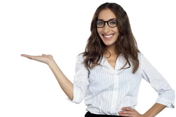 Joyous woman in spectacles posing with open palm — Stock Photo, Image