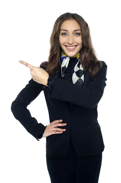 Freundlich lächelnde Stewardess zeigt weg — Stockfoto