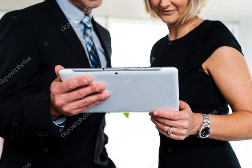 Business colleagues watching videos on tablet