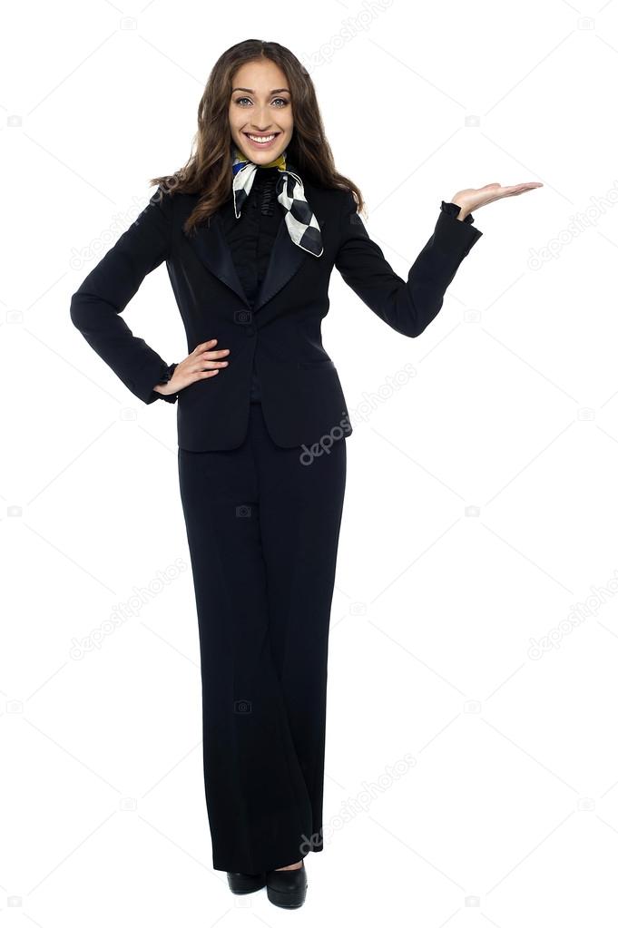 Pretty air hostess presenting copy space with open palm