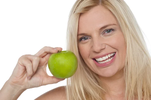 Closeup tiro de uma mulher alegre segurando uma maçã — Fotografia de Stock