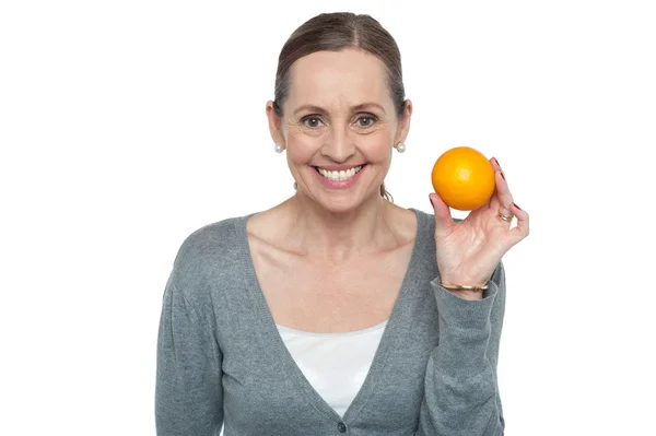Retrato de una mujer sosteniendo una naranja — Foto de Stock