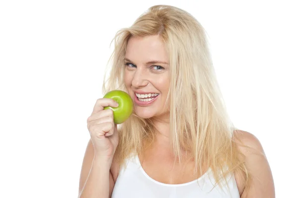 Health conscious woman about to take bite from green apple Stock Image