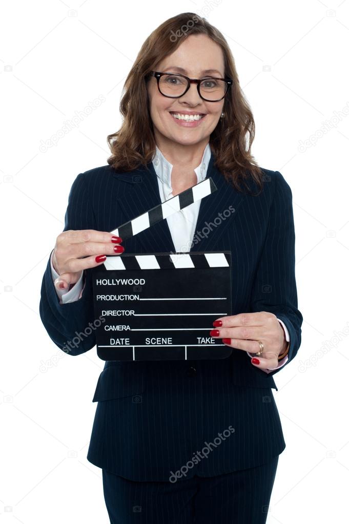 Gorgeous corporate woman holding a clapperboard