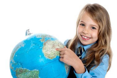 Pretty school child holding globe and pointing