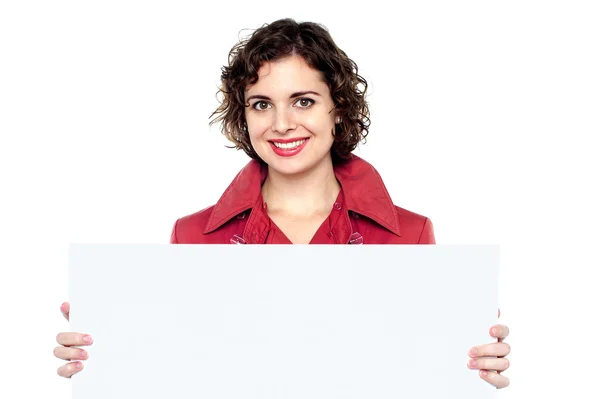 Woman in a red coat showing blank signboard — Stock Photo, Image