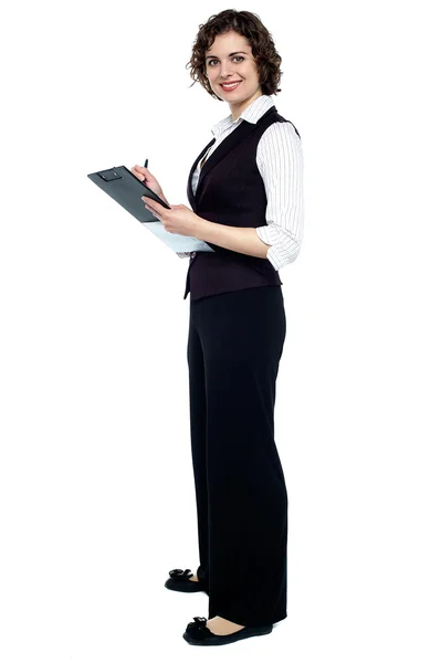 Corporate woman writing on clipboard — Stock Photo, Image