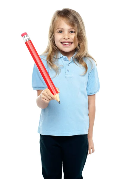 Menina segurando grande lápis vermelho — Fotografia de Stock