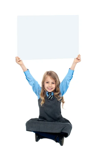 Miúdo segurando cartaz em branco acima da cabeça dela — Fotografia de Stock