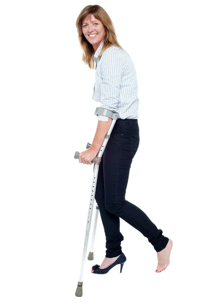 Nadenkend ogende vrouw met behulp van krukken te lopen — Stockfoto