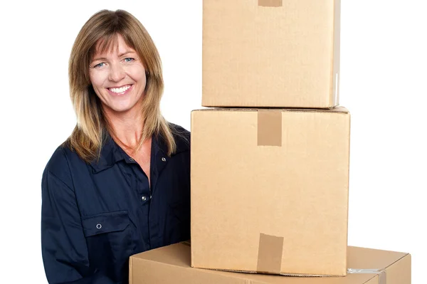 Freundliche Zustellerin mit drei gepackten Kartons — Stockfoto