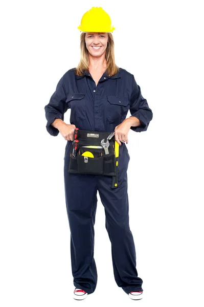 Confident woman with helmet and belt of tools — Stock Photo, Image