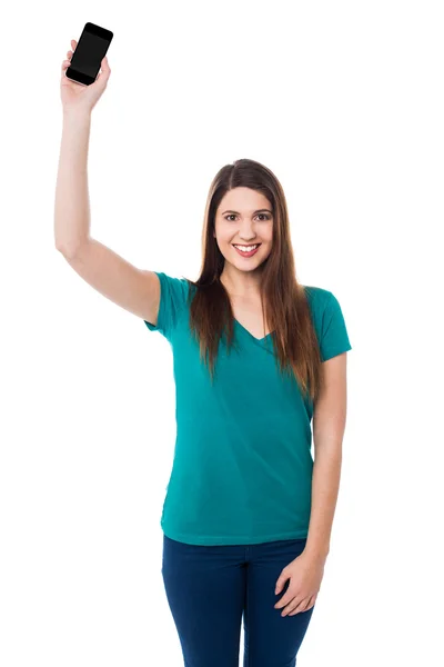Beautiful young woman holding up a cell phone — Stock Photo, Image