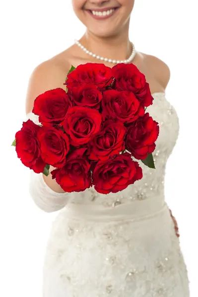 Smiling young bride holding out a rose bouquet — Stock Photo, Image