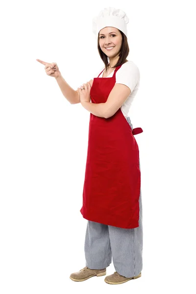 Chef feminina apontando para área de espaço de cópia — Fotografia de Stock