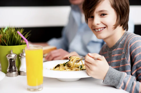 Niño disfrutando de la comida y el jugo fresco —  Fotos de Stock