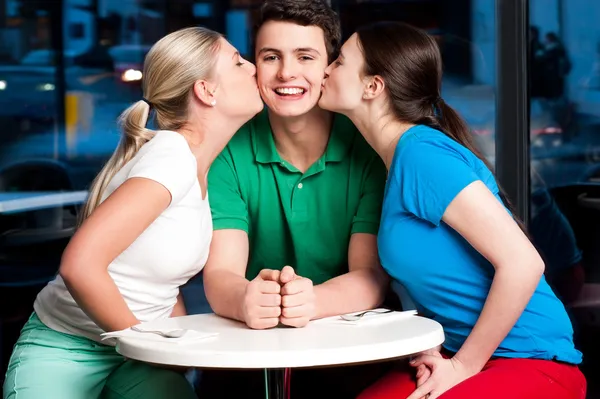 Duas meninas beijando bonito menino — Fotografia de Stock