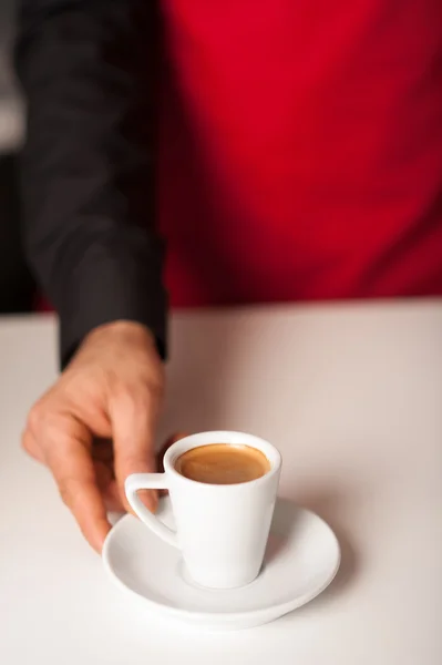 Hands of waiter serving a cup of cappucino — Stock Photo, Image