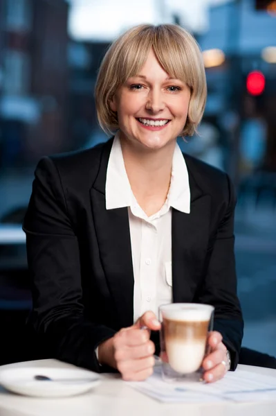 Donna d'affari sorridente che prende un caffè, all'aperto — Foto Stock