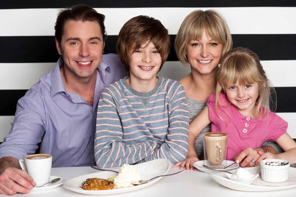Vierköpfige Familie vergnügt sich im Restaurant — Stockfoto