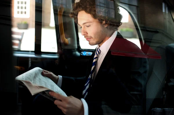 Homem lendo jornal dentro táxi táxi — Fotografia de Stock