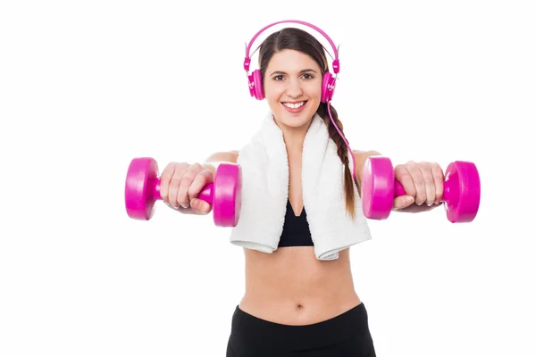 Mujer disfrutando de la música mientras hace pesas — Foto de Stock