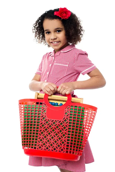 Criança bonita carregando equipamentos de matemática está na cesta — Fotografia de Stock