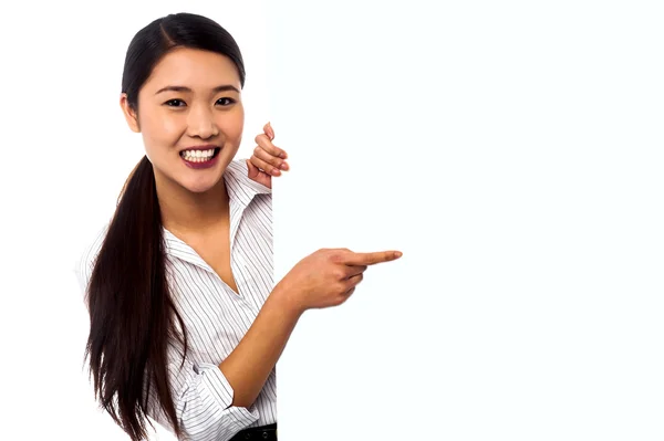 Business lady pointing towards ad on billboard — Stock Photo, Image