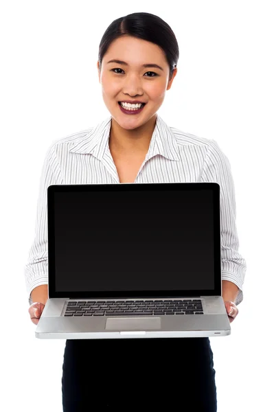 Smiling saleswoman presenting brand new laptop — Stock Photo, Image