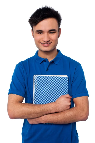 Estudante sorrindo abraçando seu livro de anotações — Fotografia de Stock