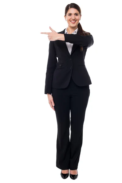 Attractive corporate woman pointing away — Stock Photo, Image