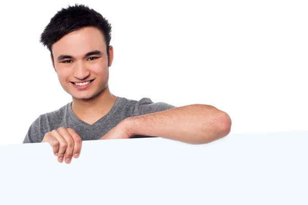 Casual young guy holding blank whiteboard — Stock Photo, Image
