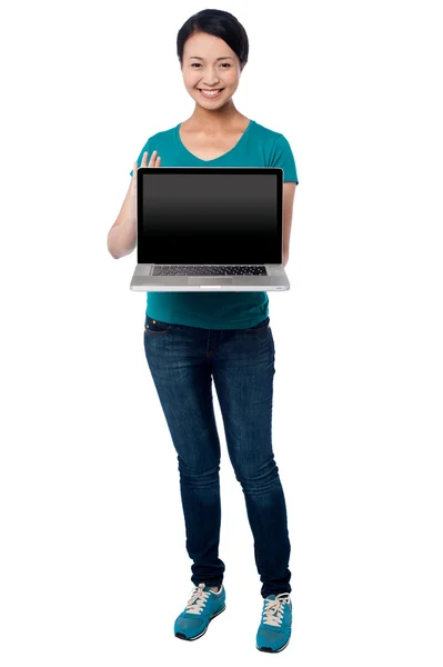 Salesgirl presenting brand new laptop for sale — Stock Photo, Image